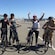 Five Guests straddling E bikes in a parking lot